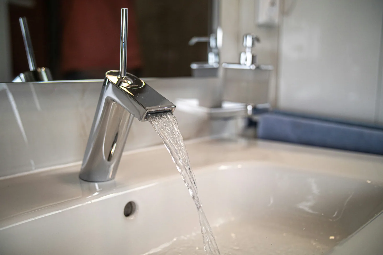 A new chrome kitchen faucet running water into a sink