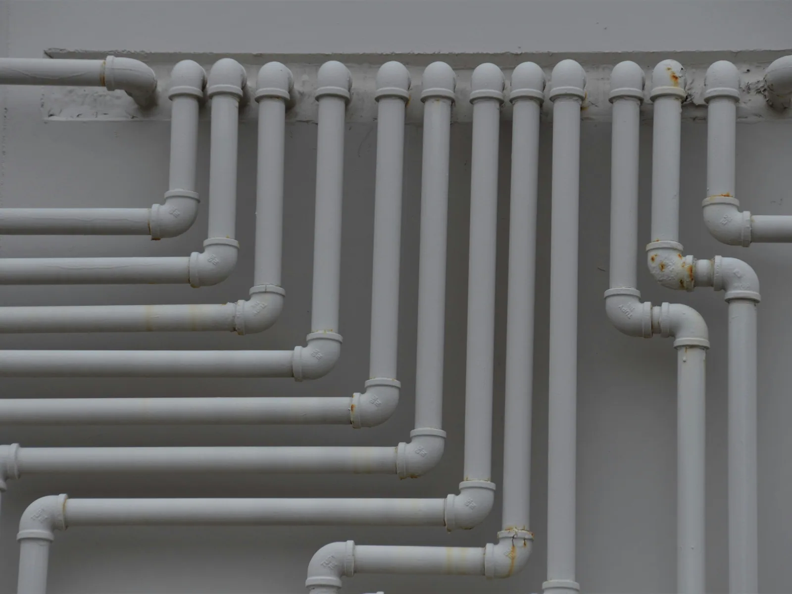Residential water supply pipe manifold with shutoff valves installed on a wall