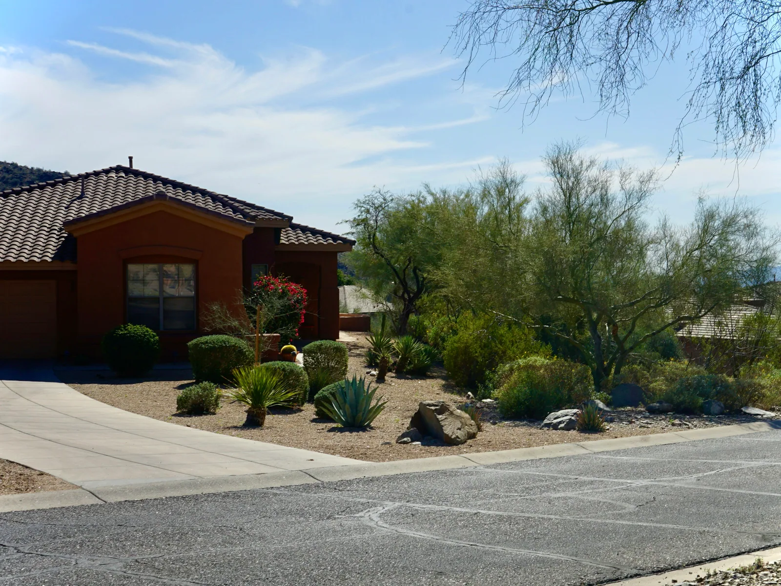 Exterior of a single-story Las Vegas residential rental home with tile roof and desert rock landscaping